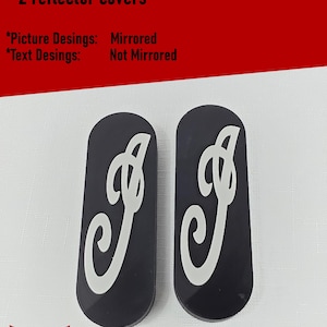 May include: Two black oval reflector covers featuring a white stylized letter C design. The image includes text: What you get in your order - 2 reflector covers, Picture Desings: Mirrored, Text Desings: Not Mirrored, and Silver Harmony Studios LLC.