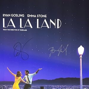 May include: A movie poster for the film "La La Land" featuring Ryan Gosling and Emma Stone dancing on a rooftop overlooking a city skyline at night. The poster has a blue background with white stars and the title of the film in large white letters. The poster also includes the text "Here's to the fools who dream." and "From the director of Whiplash."