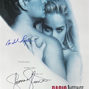 May include: A movie poster for the film "Basic Instinct" featuring Michael Douglas and Sharon Stone. The poster is in blue tones and features a close-up of the actors' faces. The title of the film is in large, bold letters at the bottom of the poster.