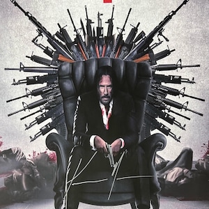 May include: A movie poster for John Wick 4, featuring Keanu Reeves as John Wick sitting on a throne made of guns. The poster has a red and black color scheme and the text "John Wick 4" is in large, bold letters. The poster also includes the text "Coming to Hunts in 3.24.23" and "In Dolby Cinema REALD 3D and IMAX".