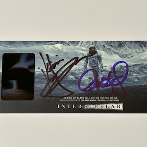May include: A rectangular card featuring a scene from the movie "Interstellar." The image shows a figure in a spacesuit against a backdrop of a stormy landscape. The card includes the film's title and text: "THE END OF EARTH WILL NOT BE THE END OF US."