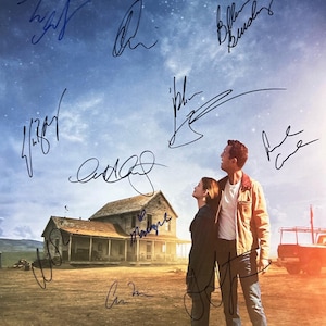 May include: A movie poster for the film Interstellar, featuring a couple standing in a field with a house in the background. The poster is signed by the cast members: Matthew McConaughey, Anne Hathaway, Jessica Chastain, and Michael Caine. The text on the poster reads: "Mankind was born on Earth. It was never meant to die here. From the director of the Dark Knight Trilogy and Inception. Interstellar. In theatres and IMAX everywhere November 7."
