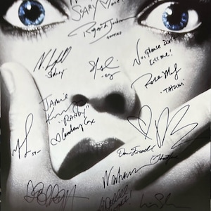 Peut inclure: Une photo en noir et blanc d'un visage de femme avec le mot "SCREAM" imprimé en lettres blanches en bas. La photo est signée par le casting du film "Scream", y compris Neve Campbell, David Arquette, Courteney Cox, Jamie Kennedy, et d'autres.