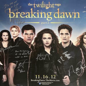 Puede incluir: Un póster de película firmado para The Twilight Saga: Breaking Dawn, Parte 2. El póster presenta a los miembros principales del reparto, incluyendo a Kristen Stewart, Robert Pattinson y Taylor Lautner. El póster está firmado por los miembros del reparto con un marcador negro.