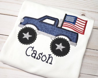 Könnte beinhalten: Ein weißes T-Shirt mit einem blauen Monstertruck-Design und einer amerikanischen Flagge. Der Truck hat einen weißen Stern auf jedem Reifen. Der Name "Cason" ist auf das Shirt gestickt.