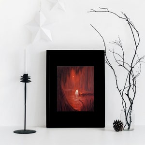 May include: A framed painting of a dark, red forest scene with a white figure standing on a wooden dock. The figure is surrounded by trees and water. The painting is in a black frame and is hanging on a white wall.