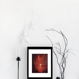 May include: A framed print of a painting depicting a red forest scene with a white figure standing on a wooden dock. The figure is facing away from the viewer and the scene is lit by a bright light in the distance.