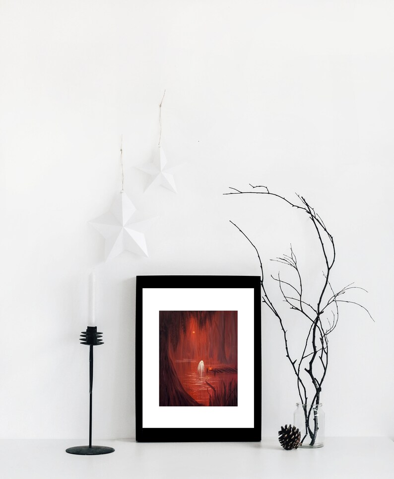 May include: A framed print of a painting depicting a red forest scene with a white figure standing on a wooden dock. The figure is facing away from the viewer and the scene is lit by a bright light in the distance.