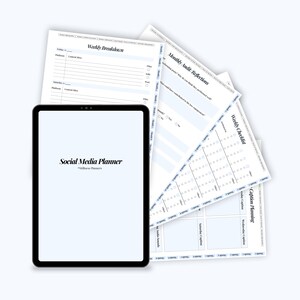 May include: A black tablet with the text "Social Media Planner" is displayed in front of several sheets of paper. The papers include a weekly breakdown, monthly audit reflections, and a weekly checklist. The papers are white with blue lines.