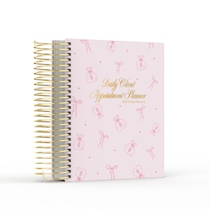 May include: A light pink spiral-bound planner with gold wire binding. The cover features a repeating pattern of small pink line-art bows and pouches, with the gold text Daily Client Appointment Planner and Stillness Planners printed centrally.