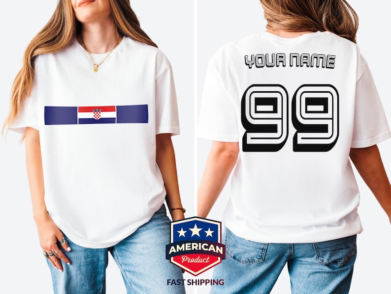 May include: A white short-sleeve t-shirt featuring a horizontal blue stripe with the Croatian flag in the center on the front. The back of the shirt displays the text YOUR NAME above the large black outlined numbers 99 in a bold athletic font.