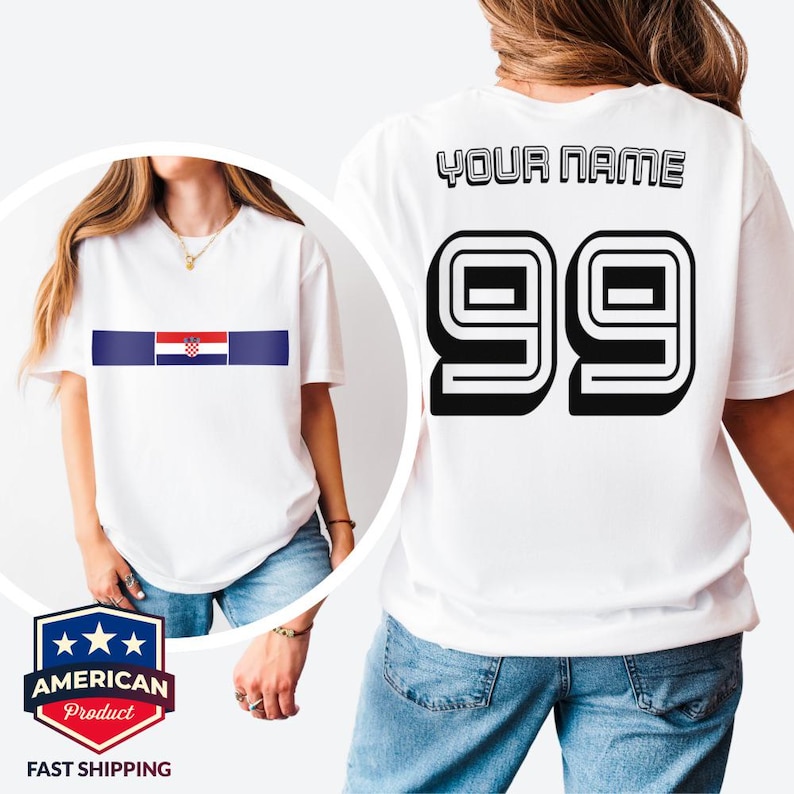 May include: A white short-sleeved t-shirt featuring a horizontal blue stripe with the Croatian flag in the center on the front. The back displays the text YOUR NAME in black block letters above the large black outlined number 99.