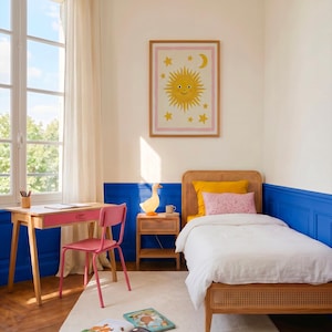 Op de afbeelding: Een lichte, uitnodigende kinderkamer met een speels thema. Voorzien van een houten bed, een roze bureau en stoel, en een ingelijste illustratie van een lachende zon en sterren. De kamer is geschilderd in wit en blauw met een wit tapijt.