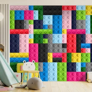 Può includere: Un murale colorato a parete con un motivo di blocchi di plastica multicolori che ricordano i mattoncini LEGO. Il murale si trova in una sala giochi per bambini con una tenda a forma di teepee, animali di peluche e un carrello giocattolo.