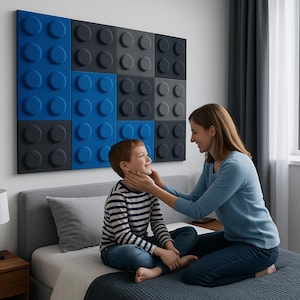 May include: A wall-mounted art piece made of large, textured blocks in blue and grey, resembling oversized toy bricks. The blocks are arranged in a grid pattern. A woman and a child are sitting on a bed in front of the art piece.