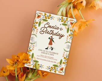 Op de afbeelding: Een witte uitnodigingskaart met een bloemige rand en de tekst "Emelie's Birthday". De kaart bevat een cartoonillustratie van een persoon die een bruine jurk en een rode hoed draagt.