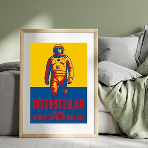 Può includere: Poster incorniciato con un astronauta stilizzato in uno schema di colori giallo, rosso e blu. La parola "INTERSTELLAR" è visualizzata in testo rosso, con "A FILM BY CHRISTOPHER NOLAN" sotto. L'opera d'arte è su uno sfondo giallo e blu.