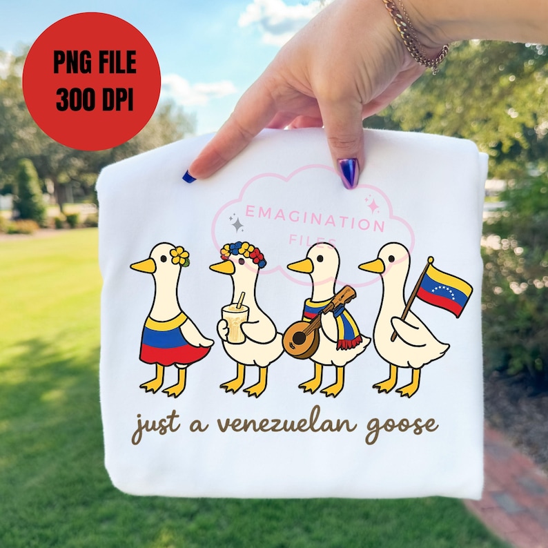 May include: White sweatshirt featuring four cartoon geese, each adorned with Venezuelan-themed accessories. The geese are wearing a flower crown, holding a drink, playing a mandolin, and holding a Venezuelan flag. Text reads "just a venezuelan goose."