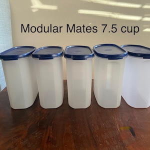 以下が含まれることがあります： 青い蓋が付いた白いプラスチック製の容器が5つあります。容器には「Modular Mates 7.5 cup」とラベルが貼られています。
