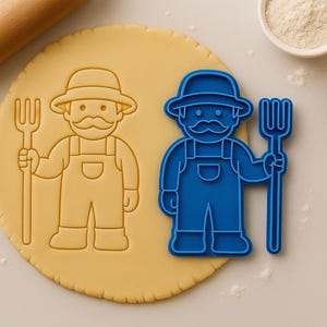 May include: A blue plastic cookie cutter shaped like a farmer holding a pitchfork. The cutter is on top of a round piece of dough.