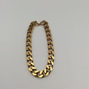 May include: A gold chain bracelet with a curb link design.