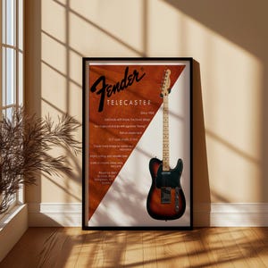 以下が含まれることがあります： 額縁に入ったFender Telecasterギターのポスター。ポスターには、茶色と黒のギターと白と茶色の背景が描かれています。ポスターのテキストは「Fender TELECASTER」と書かれており、仕様と「Since 1950」というフレーズが含まれています。