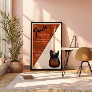 以下が含まれることがあります： Fender Telecasterギターのポスター。サンバーストカラーのギターと黒いピックガードが特徴です。ポスターには「Fender Telecaster」と仕様が記載されています。ポスターは植物と机のある部屋に飾られています。