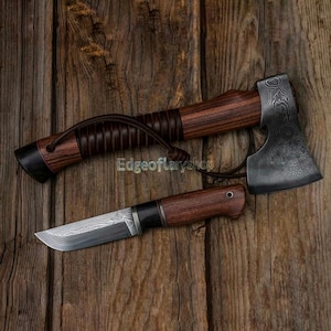 May include: Axe and knife set with wooden handles and patterned steel blades. The axe has a dark brown handle with a leather strap. The knife has a matching handle. The text "Edgeoflaryshop" is visible.