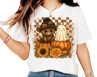 May include: White t-shirt featuring a Halloween-themed graphic. The design includes a Highland cow wearing a pumpkin hat, a ghost, pumpkins, sunflowers, and floral accents. The text "Digital download - PNG - 300DPI" is at the bottom.
