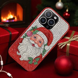 May include: A bedazzled phone case featuring a Santa Claus design. The case is covered in red and white rhinestones, with a detailed image of Santa's face and hat. The background includes a Christmas tree, red gift boxes, and a fireplace.