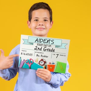 May include: Aiden's 2nd Grade first day of school sign held by a child. The sign includes the date 8.16.2025, teacher's name, and age. The sign has school supplies illustrations and is against a yellow background.