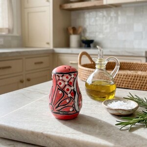 May include: A set of three ceramic mugs with a speckled, matte finish. The mugs are in shades of cream, light brown, and dark brown. Each mug has a simple, minimalist design, perfect for coffee or tea.