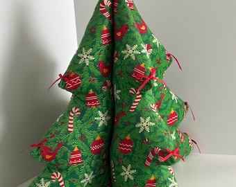 May include: A fabric Christmas tree with a green background and a festive pattern of red ornaments, birds, candy canes, and snowflakes. The tree is adorned with red bows and is a decorative holiday item.