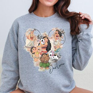 a woman wearing a sweatshirt with a picture of disney characters on it