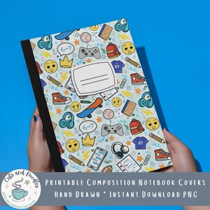 May include: A composition notebook with a black spine and a light blue cover featuring a repeating pattern of hand-drawn icons including yellow emojis, red trainers, blue skateboards, game controllers, headphones, pencils, and a white label.