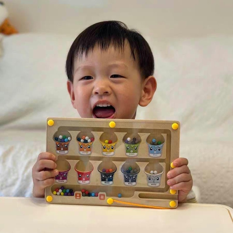 Child using Montessori busy board to sort colors and count pieces, educational toy for preschool fine motor skills