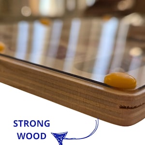 Close up of the edge of a wooden frame with a clear glass top. The wood is light brown and has a natural grain. Strong wood eco safe materials
