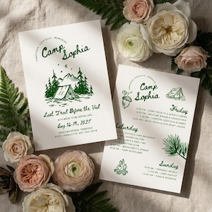 May include: Two white rectangular wedding invitation cards with dark green text and illustrations. The cards feature the text Camp Sophia, Last Trail Before the Veil, and a detailed itinerary for August 16-19, 2027, in the Smoky Mountains, Tennessee.