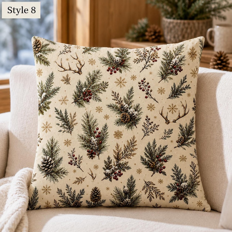 May include: A square throw pillow with a cream-coloured background featuring a repeating pattern of green pine branches, brown pinecones, red berries, deer antlers, and gold snowflakes. The top left corner displays the text Style 8.