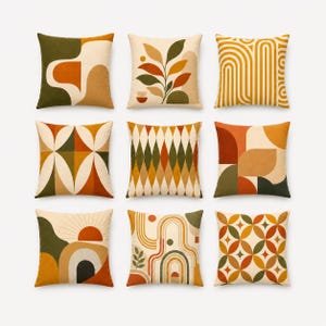 May include: A set of nine square throw pillows featuring various geometric and botanical patterns in shades of orange, olive green, cream, and brown. The designs include abstract shapes, leaf motifs, vertical lines, diamonds, and circular patterns.