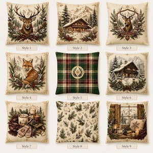May include: A collection of nine square scatter cushions featuring winter and holiday themes. Designs include a deer, a mountain cabin, a deer crest, a fox, a green and red plaid pattern, a snowy cabin, a cosy hot cocoa scene, pine branches, and a window view.