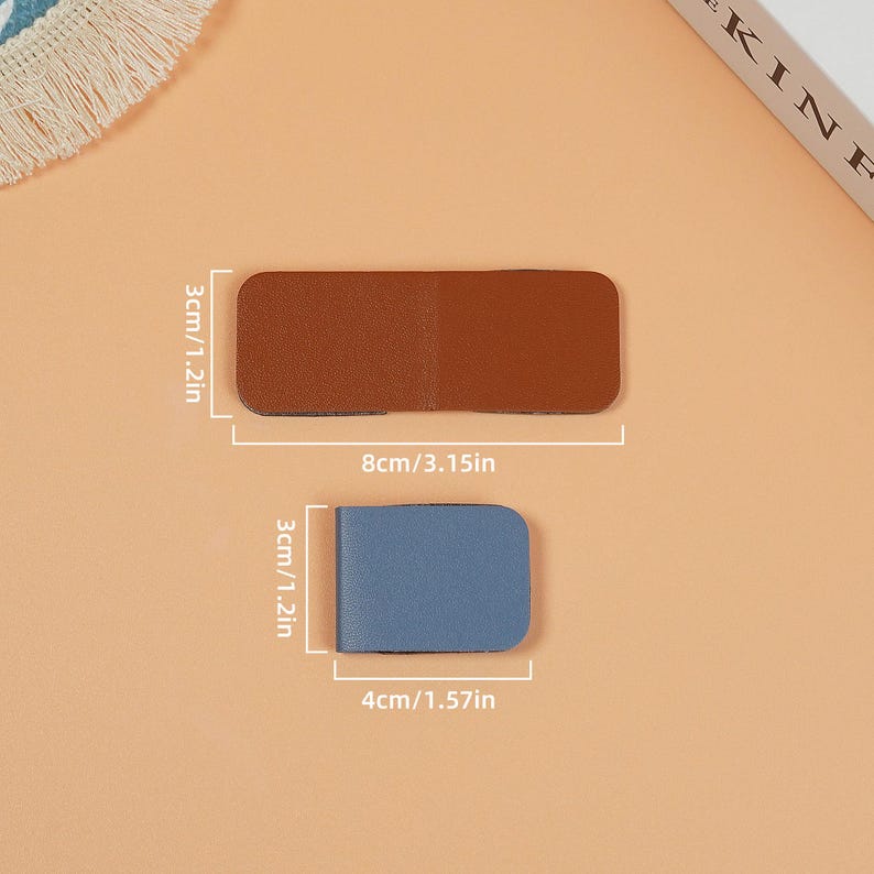 May include: Two leather bookmarks, one brown and one blue, with measurements in inches and centimeters.