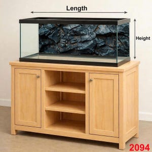 May include: A rectangular glass aquarium with a black frame, set atop a light wood cabinet. The aquarium's backdrop features a dark, textured rock design. The cabinet has two doors and open shelving. The number "2094" is visible in the bottom right corner.