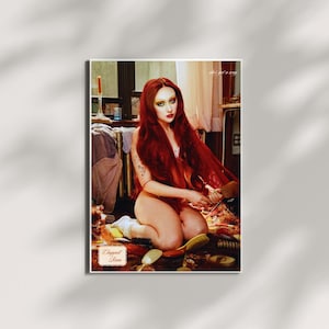 May include: A framed print featuring a woman with long red hair, seated on the floor. The image includes various hairbrushes and the text "Chopped Room" and "she's got a way". The overall aesthetic is artistic and evocative.