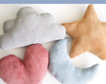 May include: Four corduroy pillows in the shapes of a cloud, star, heart, and crescent moon. The cloud is gray, the star is tan, the heart is red, and the moon is light blue. The text "Lune Pillows" is at the top left.