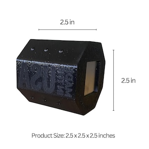 May include: A black, geometric-shaped product with the text "USA" and "FOAM" visible. The product is 2.5 x 2.5 x 2.5 inches. It has a rectangular opening on one side. The product is likely made of foam.