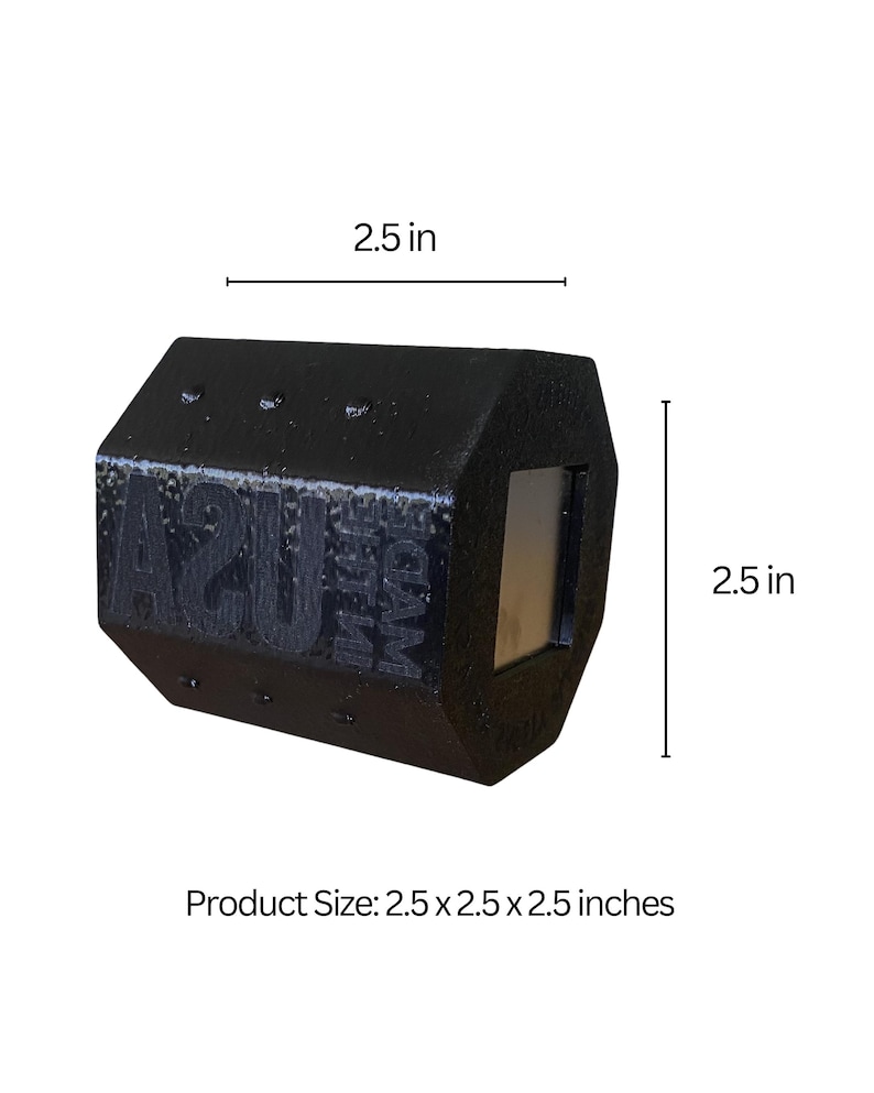 May include: A black, geometric-shaped product with the text "USA" and "FOAM" visible. The product is 2.5 x 2.5 x 2.5 inches. It has a rectangular opening on one side. The product is likely made of foam.