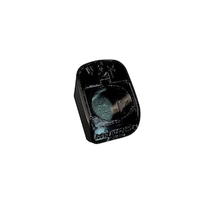 May include: Black plastic object with a raised circular design and the words 'W.A.T.E.R. PROOF' printed on it.