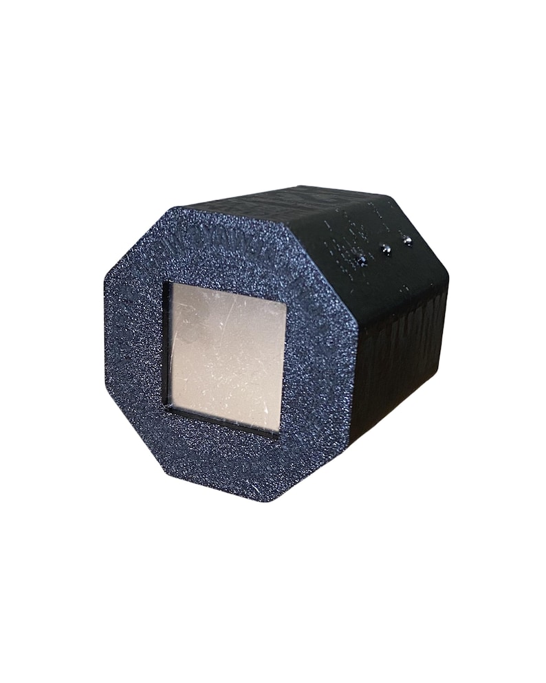 May include: A black, geometric-shaped object with a square, metallic-looking center. The object has a textured surface and appears to be made of a rigid material. The design is modern and industrial.
