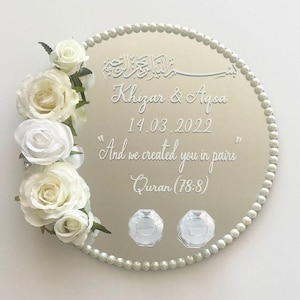 May include: A silver mirrored tray with a white pearl border. The tray has an inscription that reads "Khizar & Aqsa 14.03.2022 "And we created you in pairs" Quran (78:8)". The tray is decorated with white roses.